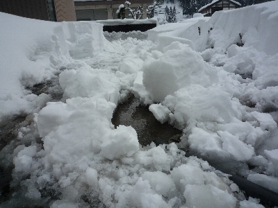 家の前を湧き水で融雪している状況